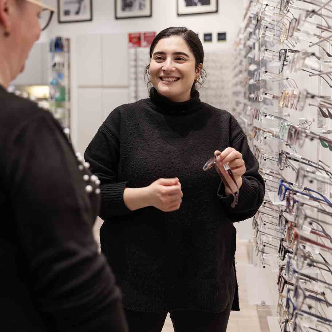 Employee from Thiele in Frederiksberg shows glasses to a customer.